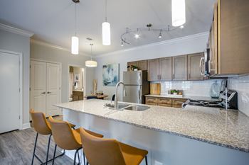 A kitchen with a white counter top and yellow chairs.