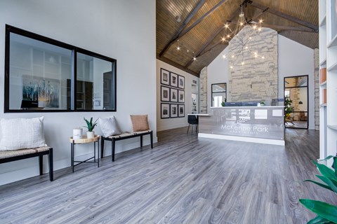 A spacious lobby with a bench and a reception desk.