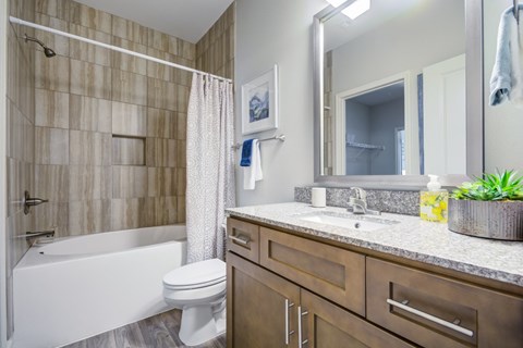 A bathroom with a white tub, sink, and toilet.
