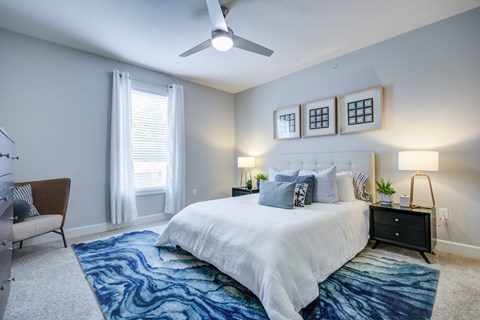 A bedroom with a large bed and a ceiling fan.