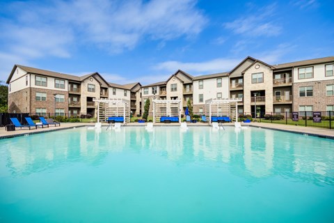 A large swimming pool in front of apartment buildings.