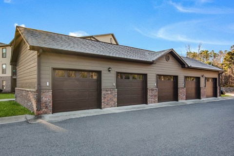 a garage with three garage doors in front of a house at The McKenzie Park Apartments, Arkansas, 72223