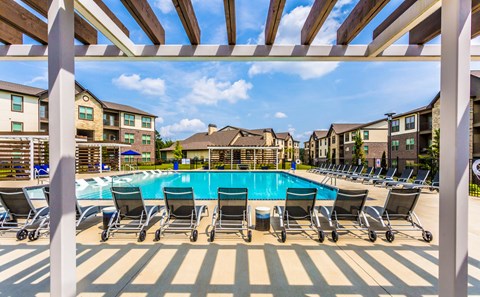 our apartments have a large swimming pool with chairs at The McKenzie Park Apartments, Arkansas