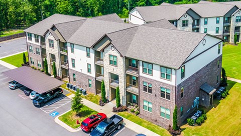 an aerial view of an apartment building with cars parked outside at The McKenzie Park Apartments, Little Rock, AR 72223