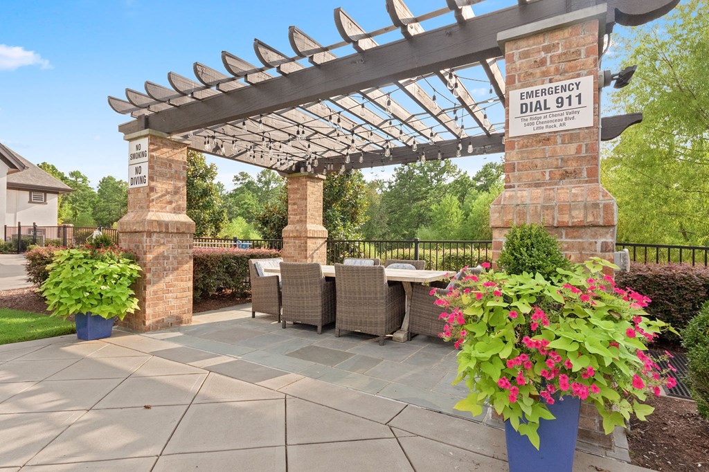 a patio with a table and chairs and a pergola at The Ridge at Chenal Valley, Little Rock