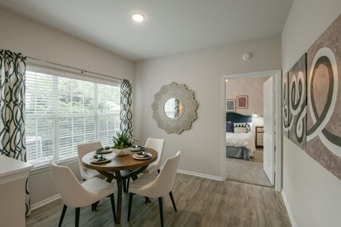 A dining room with a round table and chairs.