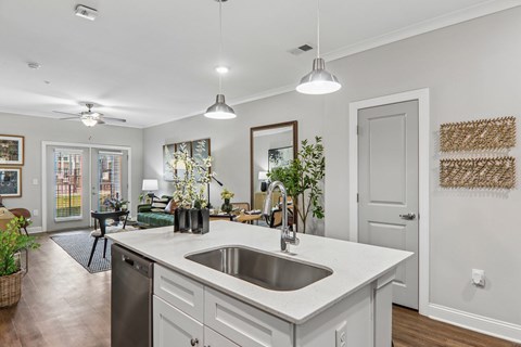 A modern kitchen with a large island and a stainless steel dishwasher.