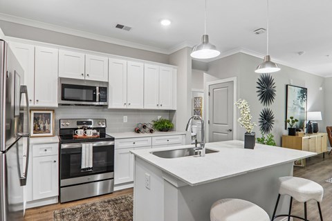 A modern kitchen with white cabinets and a large island.