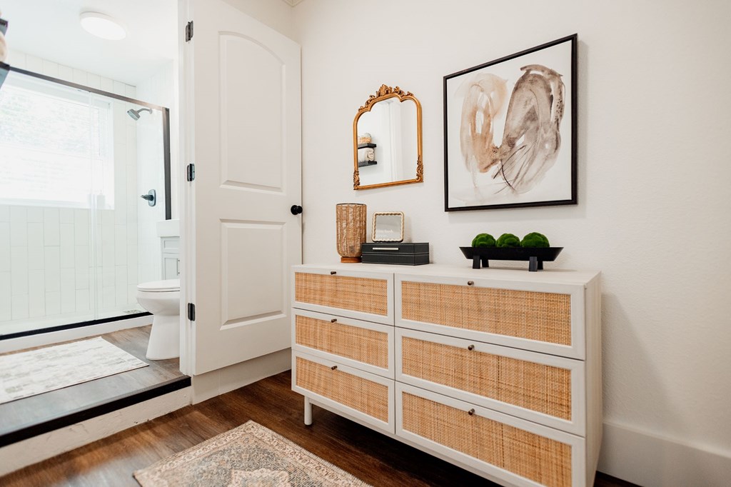 A white wooden dresser with a mirror and a painting on the wall.at Parkview Apartments, Memphis, 38104