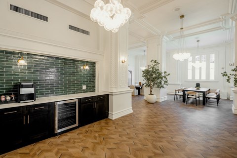 A kitchen with black cabinets and green tiled backsplash.