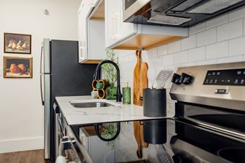 A modern kitchen with a black refrigerator and stainless steel appliances.at Parkview Apartments, Memphis