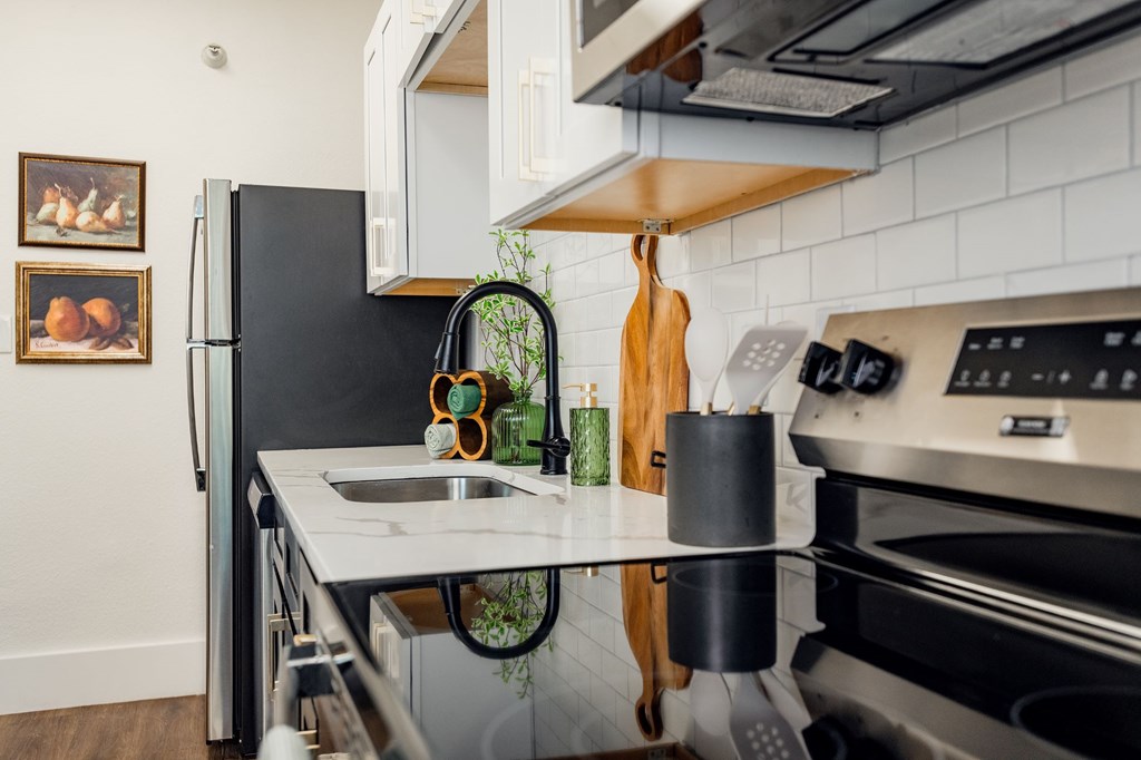 A modern kitchen with a black refrigerator and stainless steel appliances.at Parkview Apartments, Memphis Tennessee