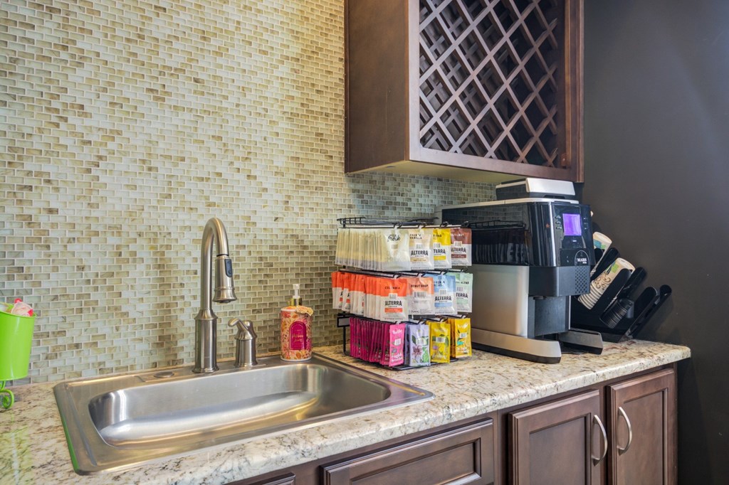 A kitchen sink with a stack of paper towels and cleaning supplies on the counter.