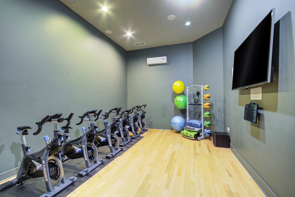 A gym with exercise bikes and a television.