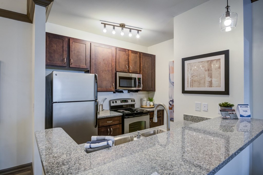 A kitchen with granite countertops and stainless steel appliances.