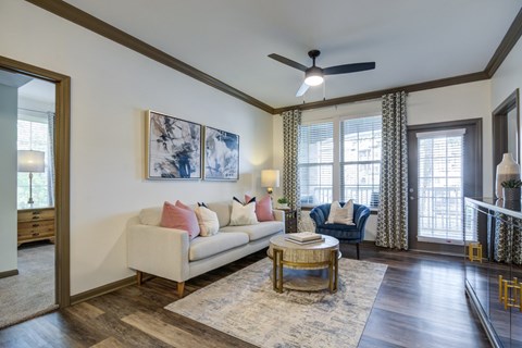 A living room with a white couch and a painting on the wall.