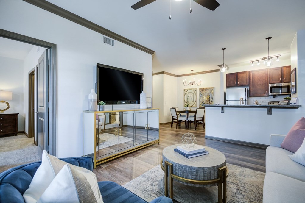 A modern living room with a blue sofa and a glass coffee table.