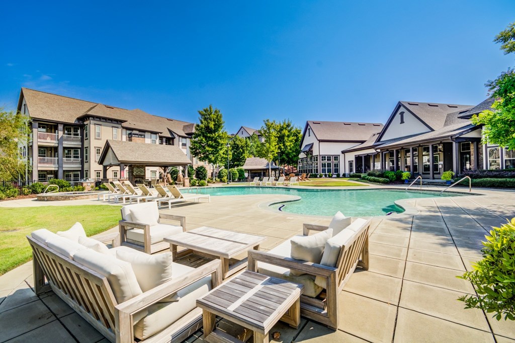 A poolside lounge area with white cushioned seating.