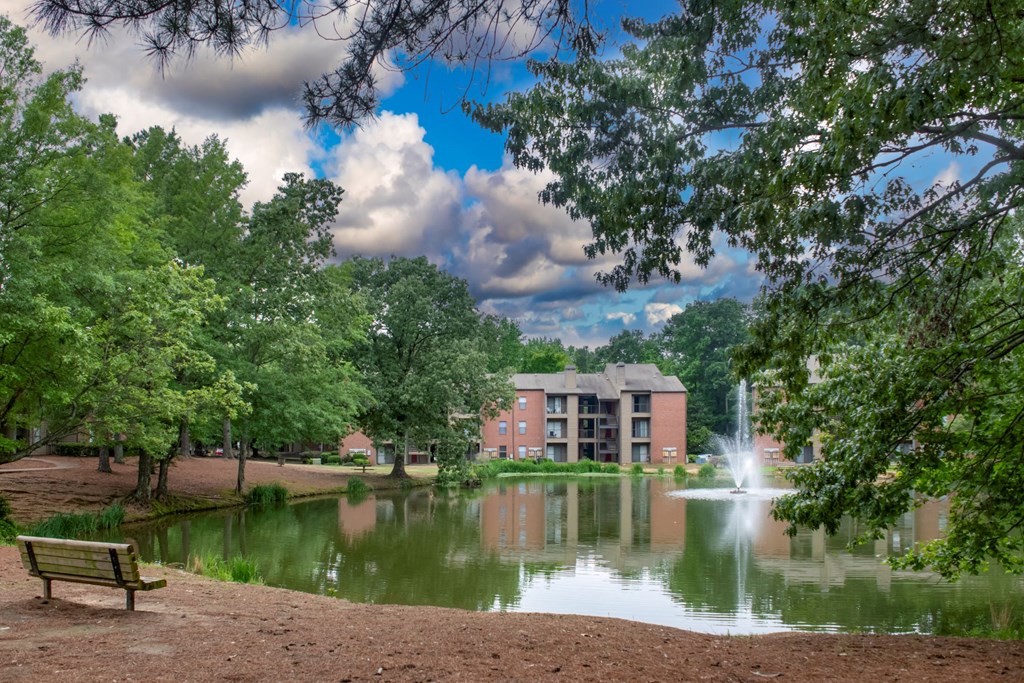 a pond with a fountain and a building in the background at The Summit Apartments, Tennessee, 38128