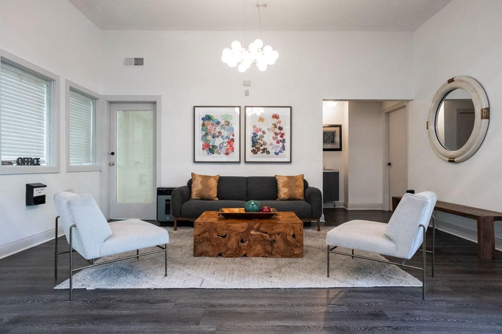 a living room with a black couch and two white chairs at The Summit Apartments, Memphis, 38128