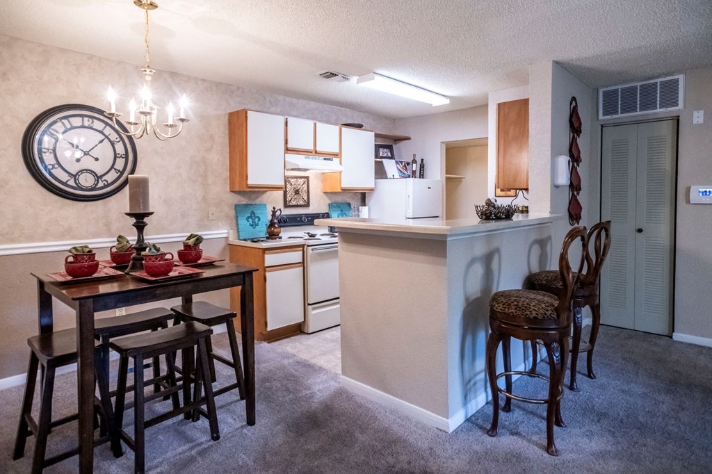 a kitchen and dining area with a large clock on the wall at The Summit Apartments, Memphis, Tennessee