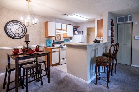 a kitchen and dining area with a large clock on the wall