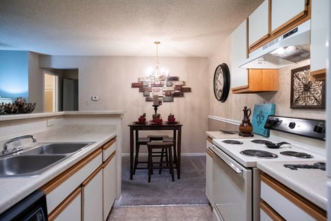 a kitchen with white appliances and a dining room with a table