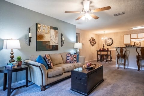 a living room with a couch and a ceiling fan