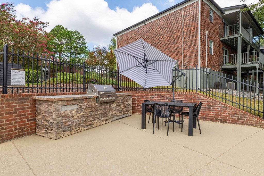 our patio has a grill and a table with chairs and an umbrella at The Waters at Chenal, Little Rock, Arkansas