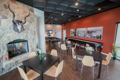 a dining room with tables and chairs and a fireplace at The Villa at River Pointe, Maumelle, AR 72213