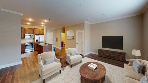 A living room with a white couch, a coffee table, and a television.