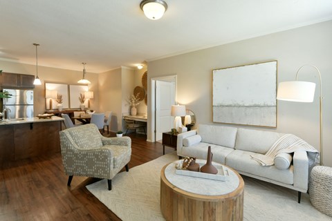 A well-lit living room with a white sofa and a wooden coffee table.