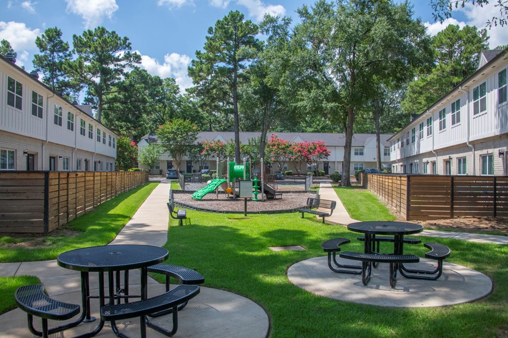 A playground area with a slide and picnic tables.