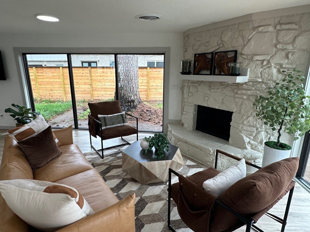 A living room with a fireplace and a stone wall. A living room with a fireplace and a stone wall.at The Garden District Apartments, Germantown, TN