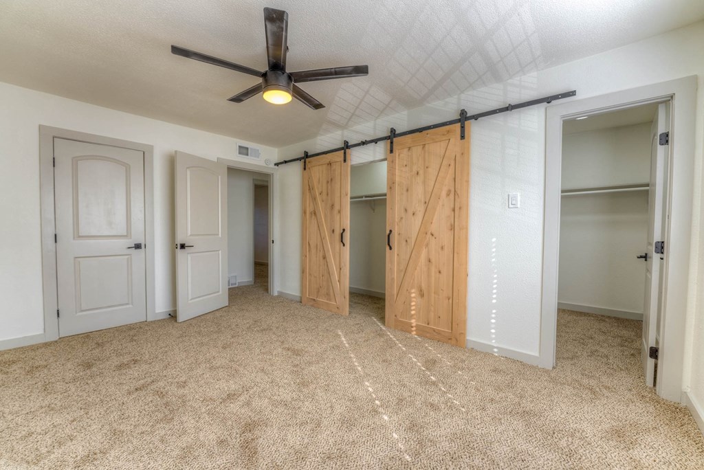 A room with a ceiling fan and sliding doors.at The Garden District Apartments, Germantown, 38138  