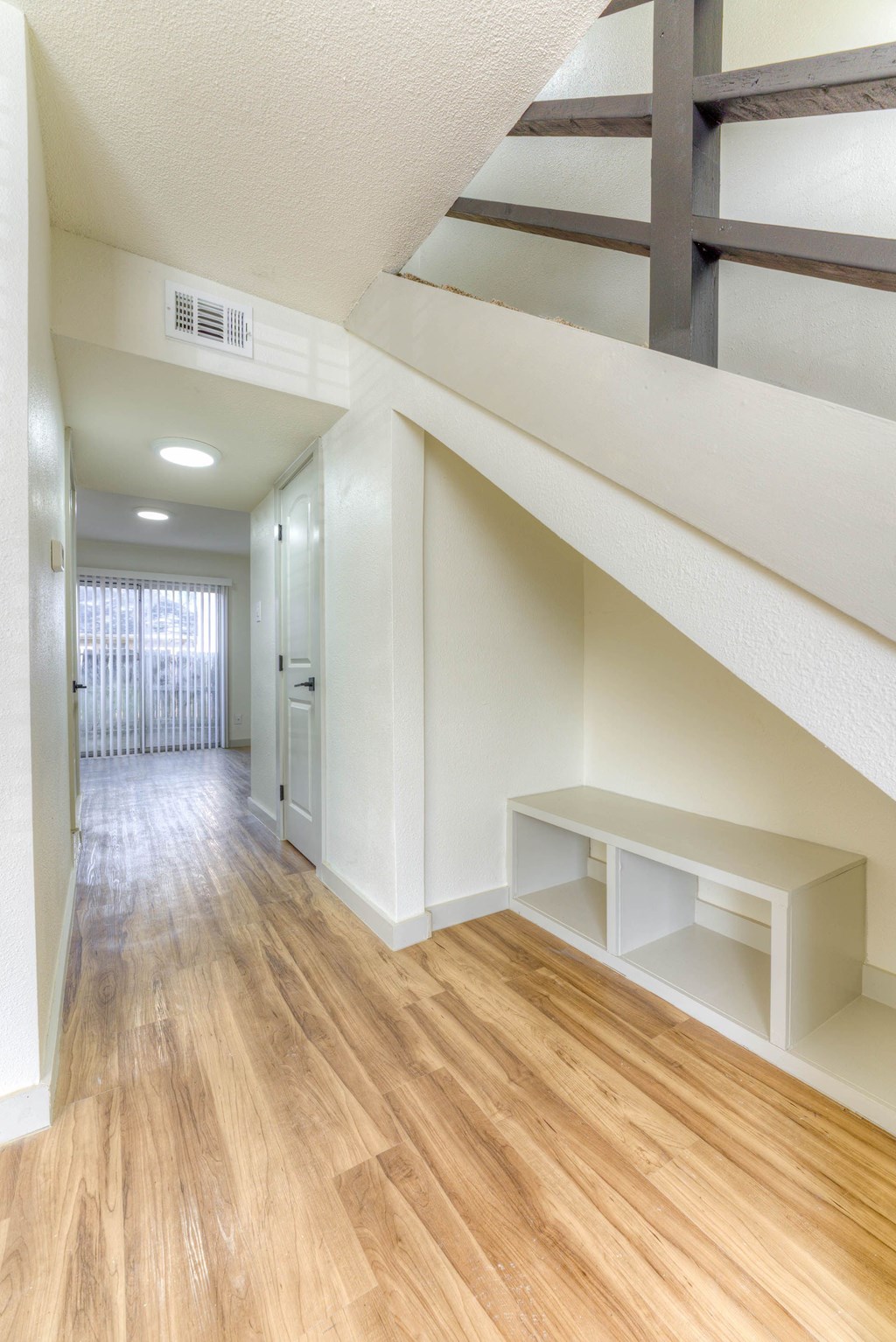 A long hallway with a bench and a window.at The Garden District Apartments, Germantown Tennessee  
