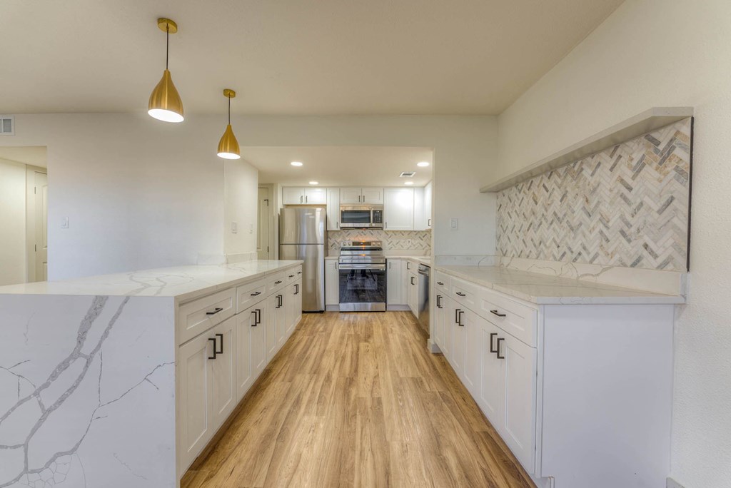 A kitchen with white cabinets and a wooden floor. A kitchen with white cabinets and a wooden floor.at The Garden District Apartments, Tennessee, 38138