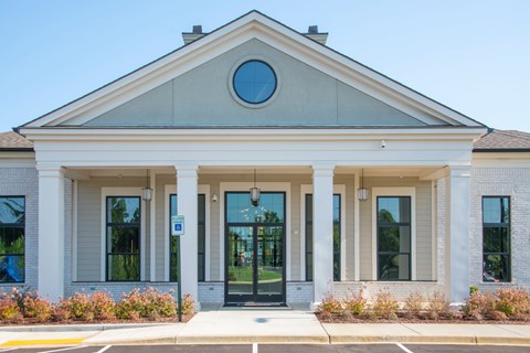 A building with a circular window on the top and a black door in the center.