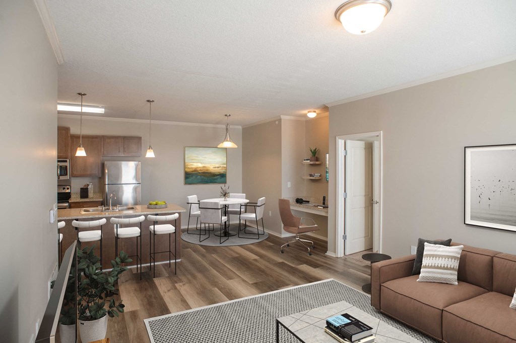 a living room with a couch a table and chairs and a kitchen in the background at Harbor Island Apartments, Memphis, TN