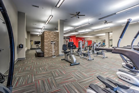 A gym with a variety of exercise equipment including treadmills, elliptical machines, and weights at Highland Row Apartments, TN, 38111