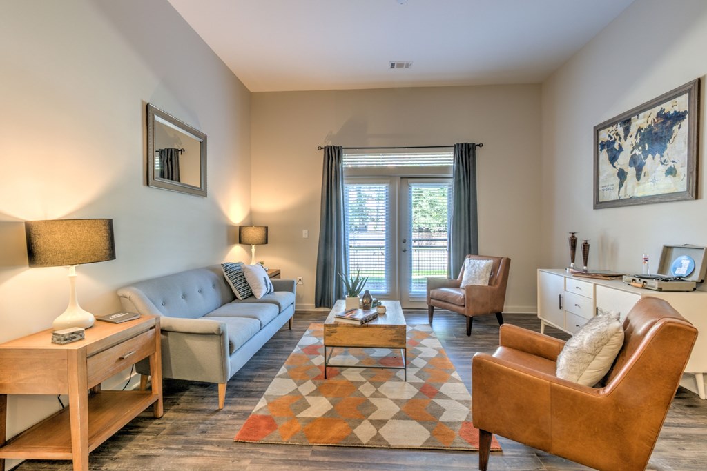 A living room with a grey couch, a brown chair, and a wooden coffee table. A living room with a grey couch, a brown chair, and a wooden coffee table at Highland Row Apartments, Memphis, 38111