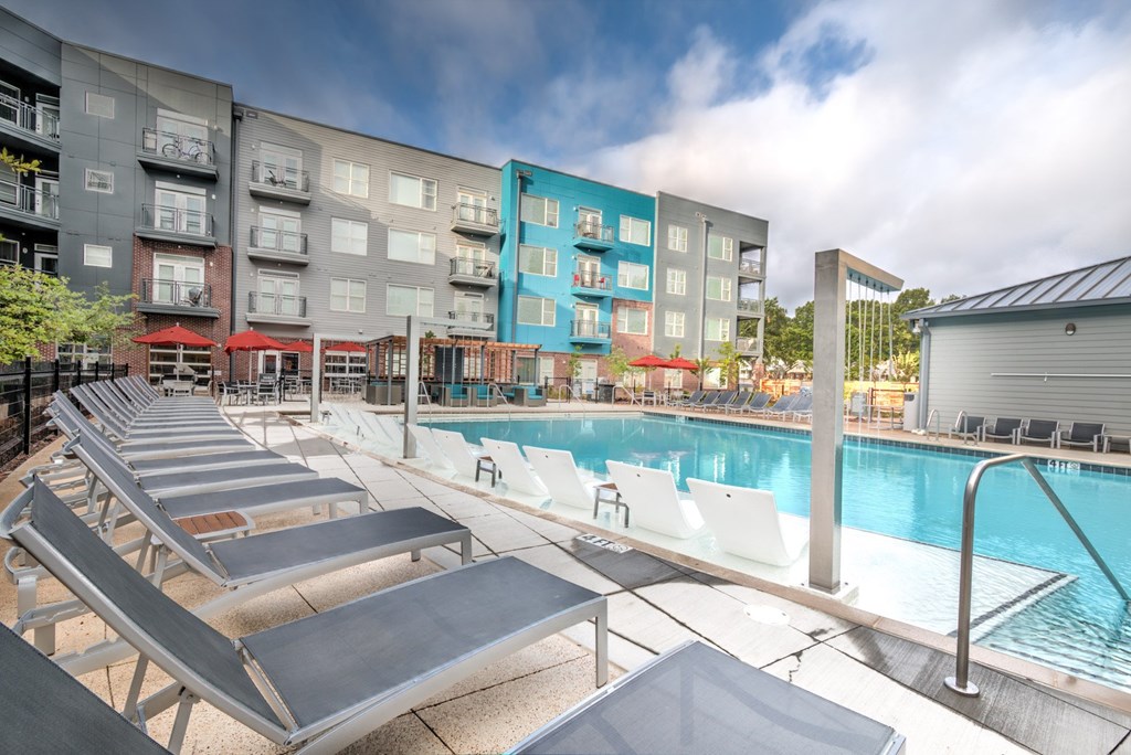 A pool area with sun loungers and a building in the background at Highland Row Apartments, TN, 38111