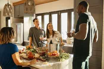 a group of people standing around a kitchen table eating food and drinking wine at Livano Avondale, Avondale, 85323