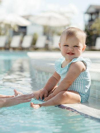 a baby sitting on the side of a swimming pool at Livano Avondale, Arizona, 85323