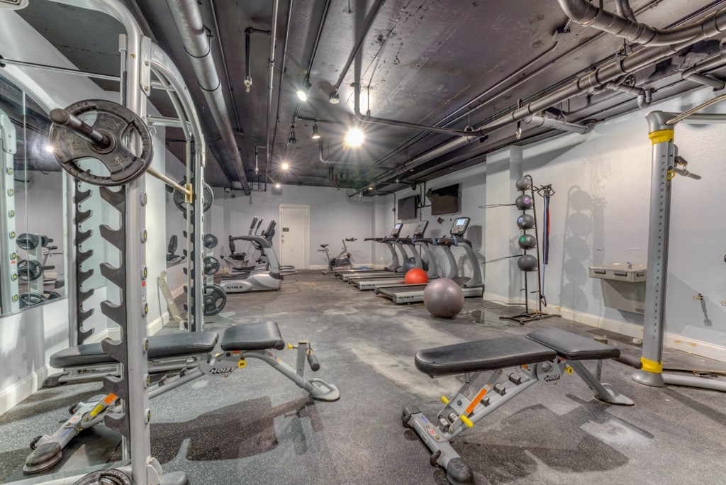 A gym with a variety of equipment including weights and benches. A gym with a variety of equipment including weights and benches.at Iris Luxury Apartments, Memphis Tennessee