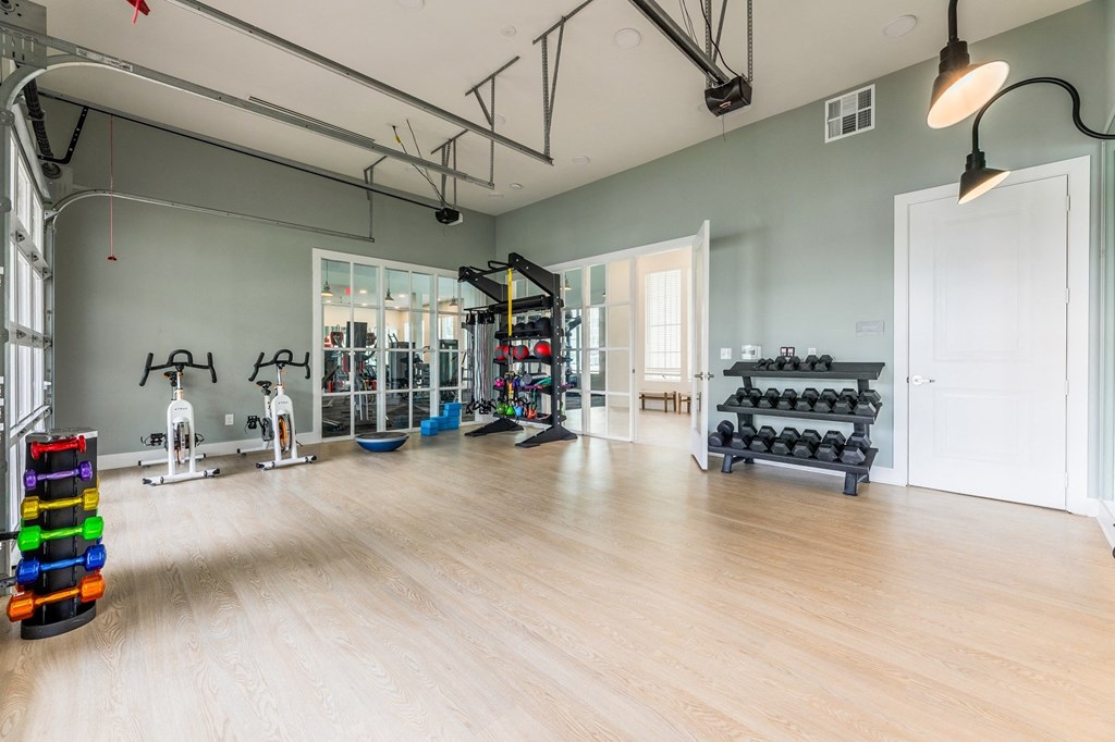 a spacious fitness room with hardwood floors and a wall of windows at The Livano Kemah, Kemah, 77565