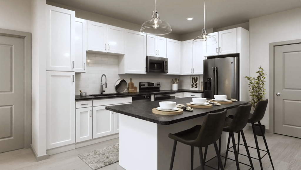 an open kitchen with white cabinets and a black counter top