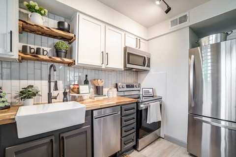 A modern kitchen with a stainless steel refrigerator and wooden countertops.