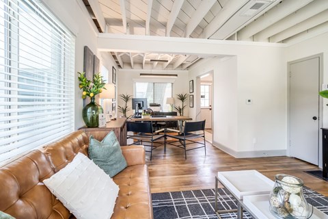 A living room with a brown leather couch and a white coffee table.