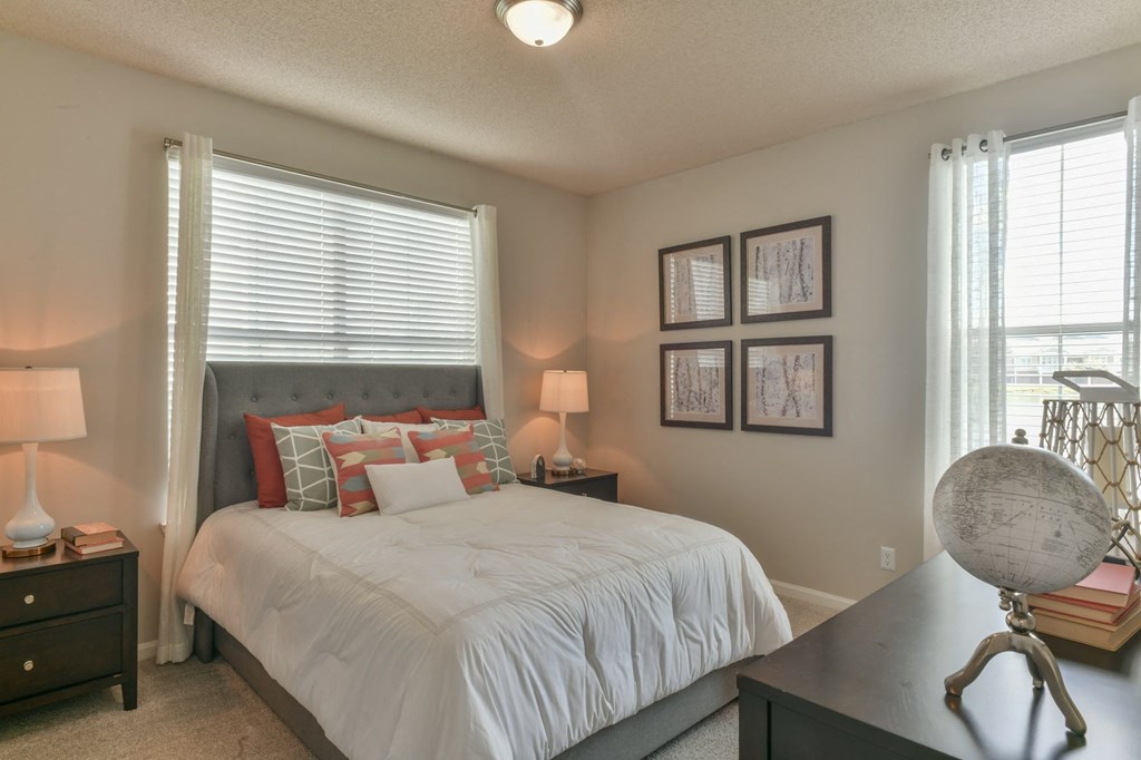 a bedroom with a bed and a dresser and a window